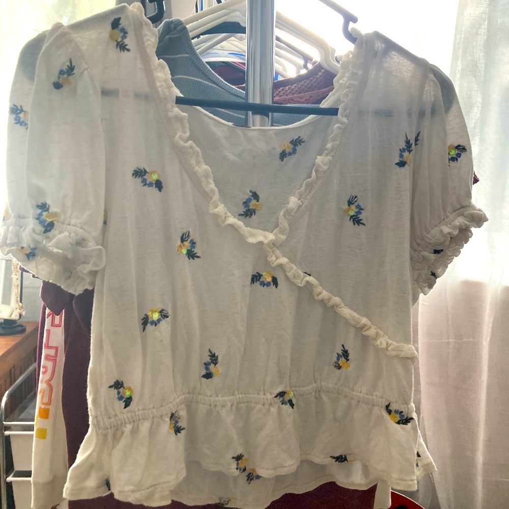 Free people size small. White shirt with yellow and blue flowers.